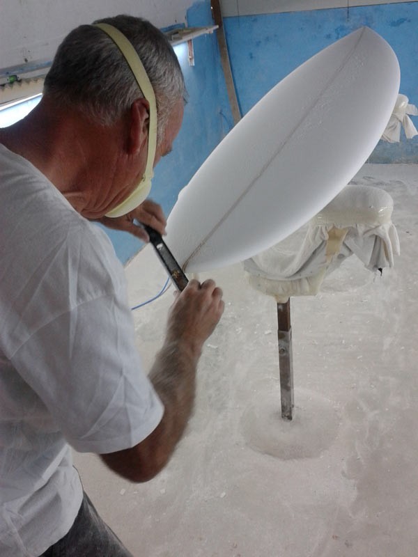 Phil Grace working on a surfboard in the shaping bay